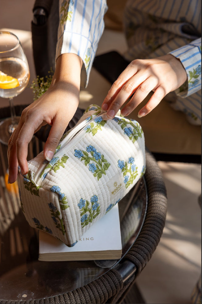 blue and green floral quilted cosmetic bag in a lifestyle image