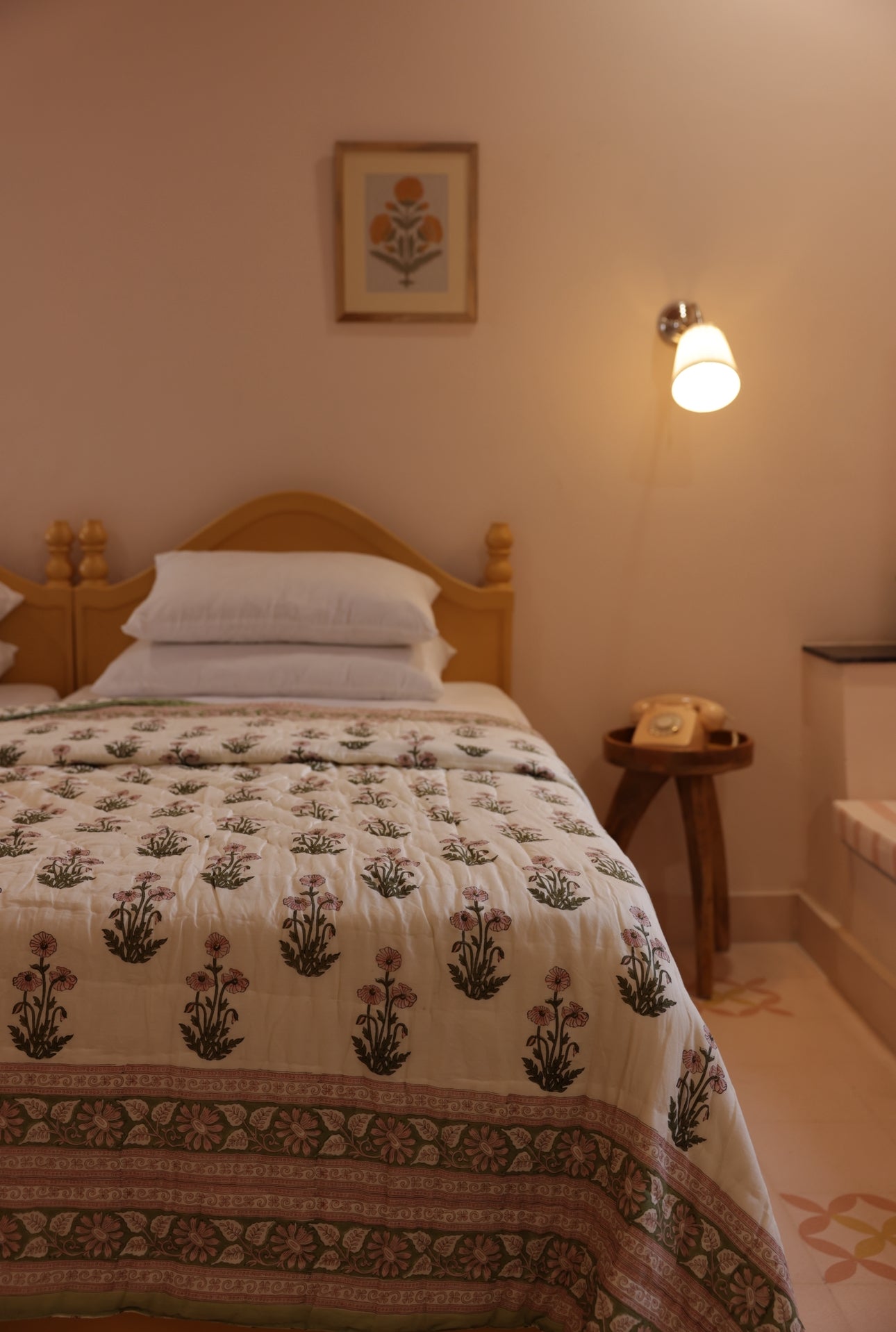 Dimly lit bedroom showing paxford willow quilt laid out on bed