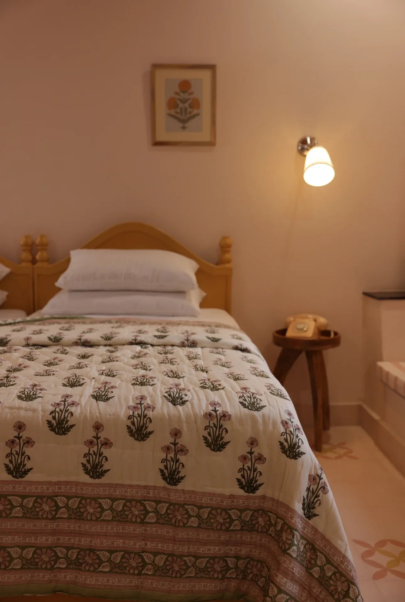 Dimly lit bedroom showing paxford willow quilt laid out on bed