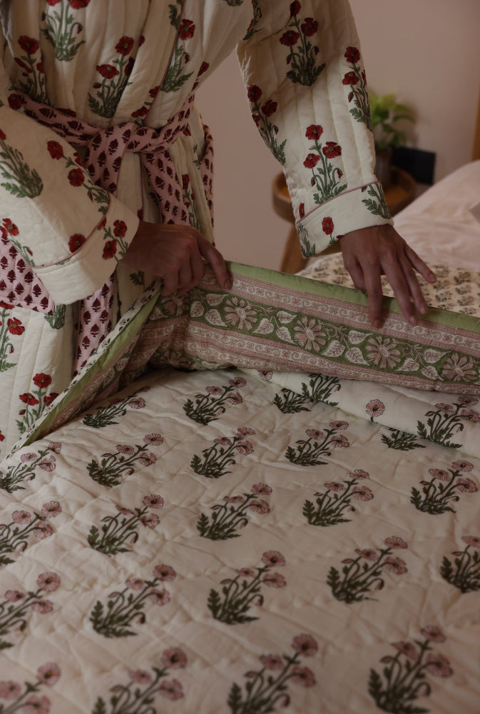 Model making the bed with condicote poppy quilt