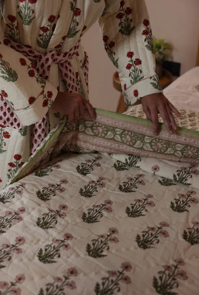 Model making the bed with condicote poppy quilt