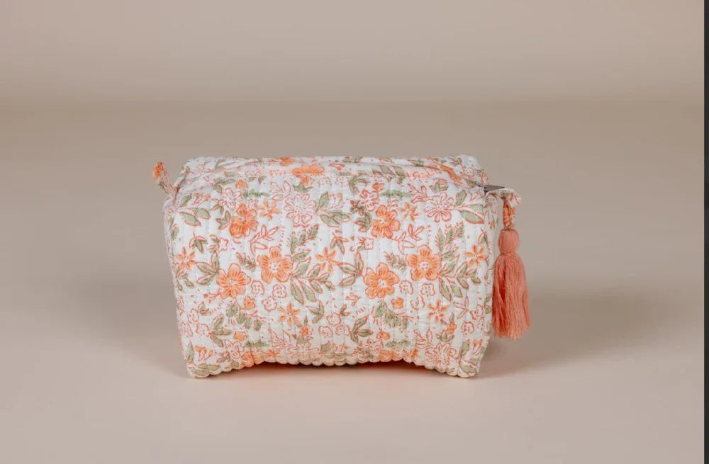 Floral-patterned cosmetic bag with tassels on a beige background