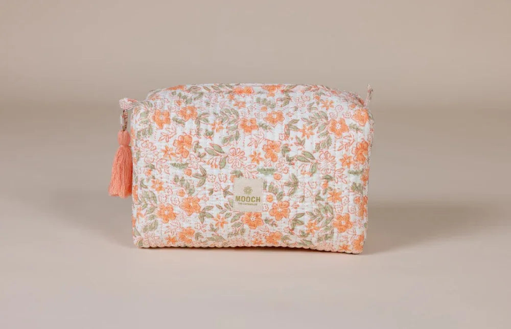 Floral patterned wash bag with tassel on a beige background