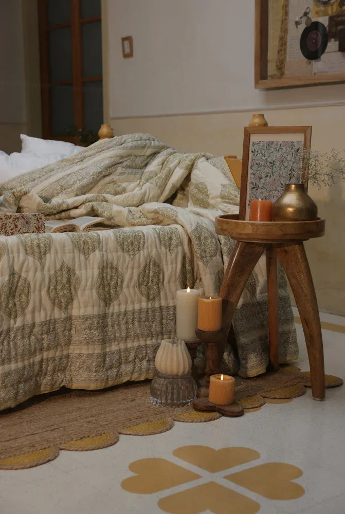 Cosy bedroom with kiftsgate stone bedspread, wooden side table, and decorative items.