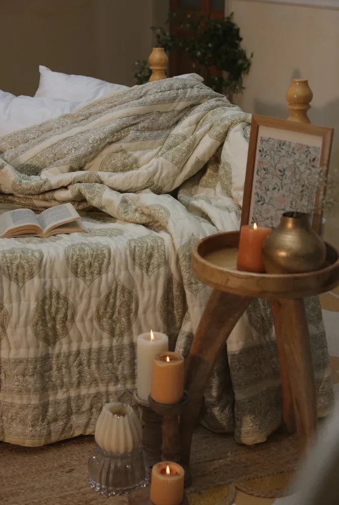 Cosy bedroom scene with a bed, candles, and kiftsgate stone bedspread.