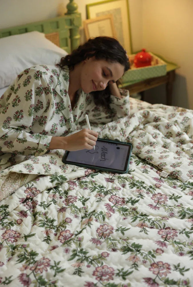 Model laid on paxford willow quilt drawing on a tablet