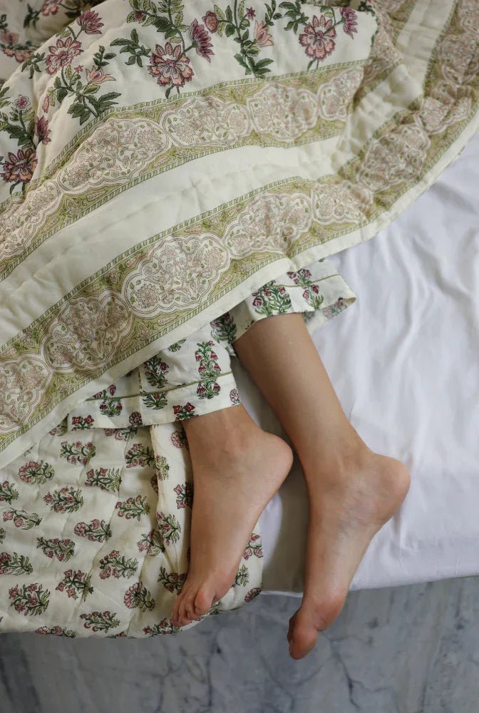 Models feet poking out under bottom of quilt