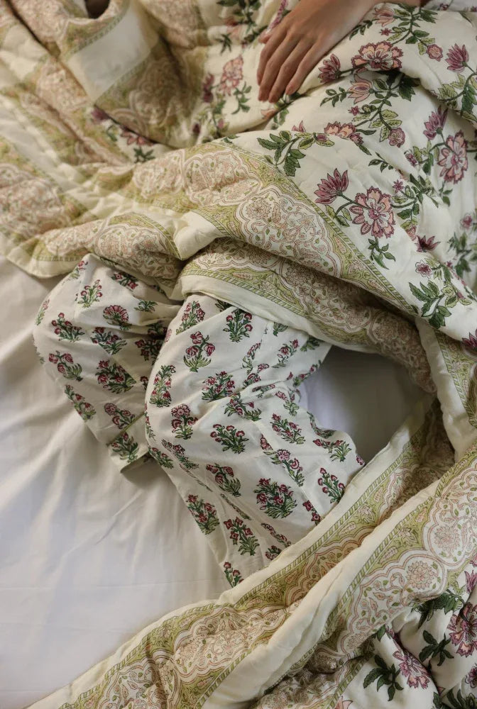 Floral patterned quilt with a models hand partially visible