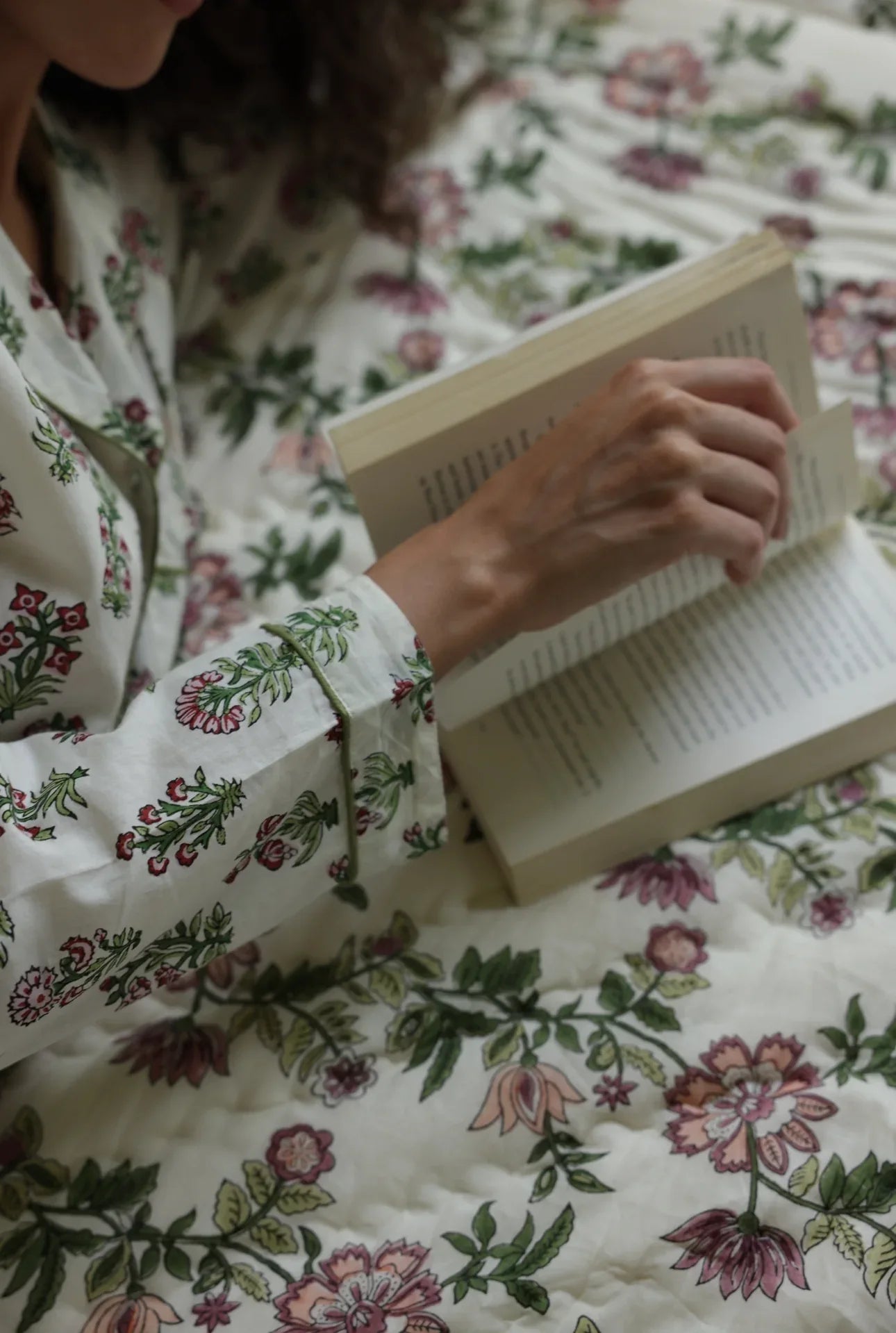 Model laid down on paxford willow quilt flicking through pages