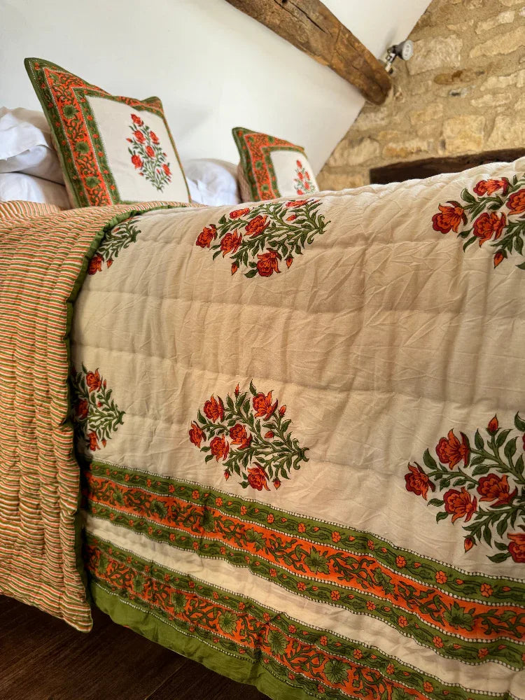 Decorative Wilson amber quilt with floral patterns on a bed in a rustic room.