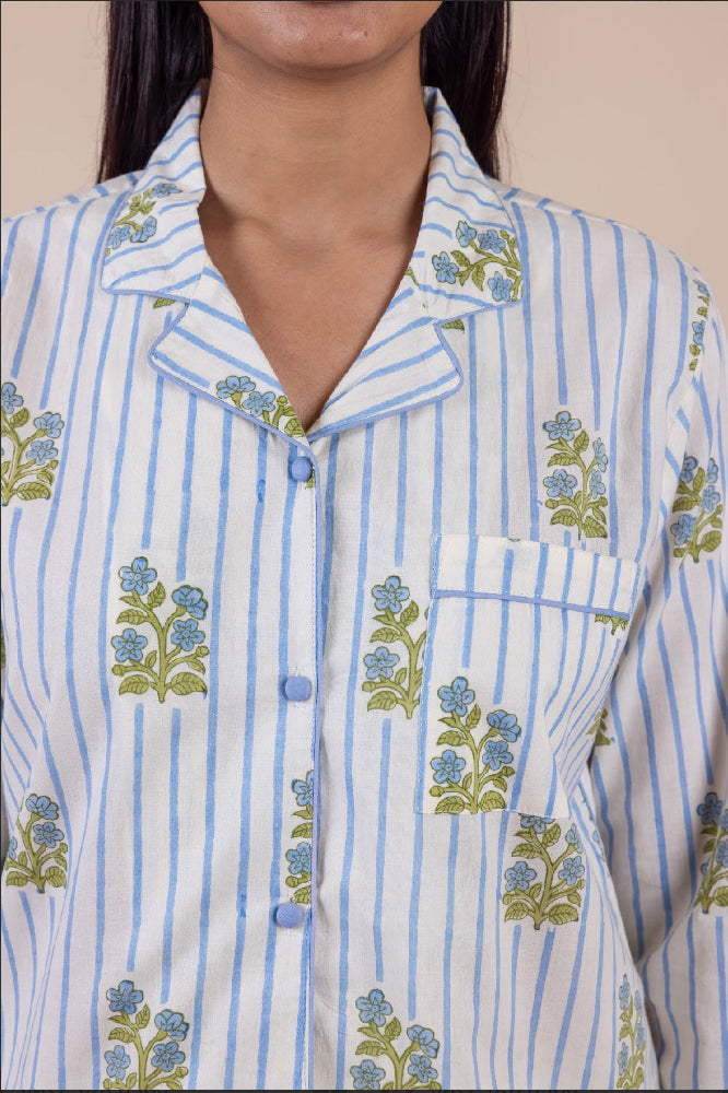Close-up of a person wearing a blue and white striped pyjama shirt with floral patterns.