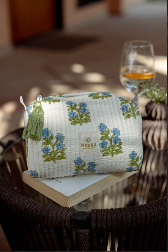 blue and green floral quilted cosmetic bag in a lifestyle image