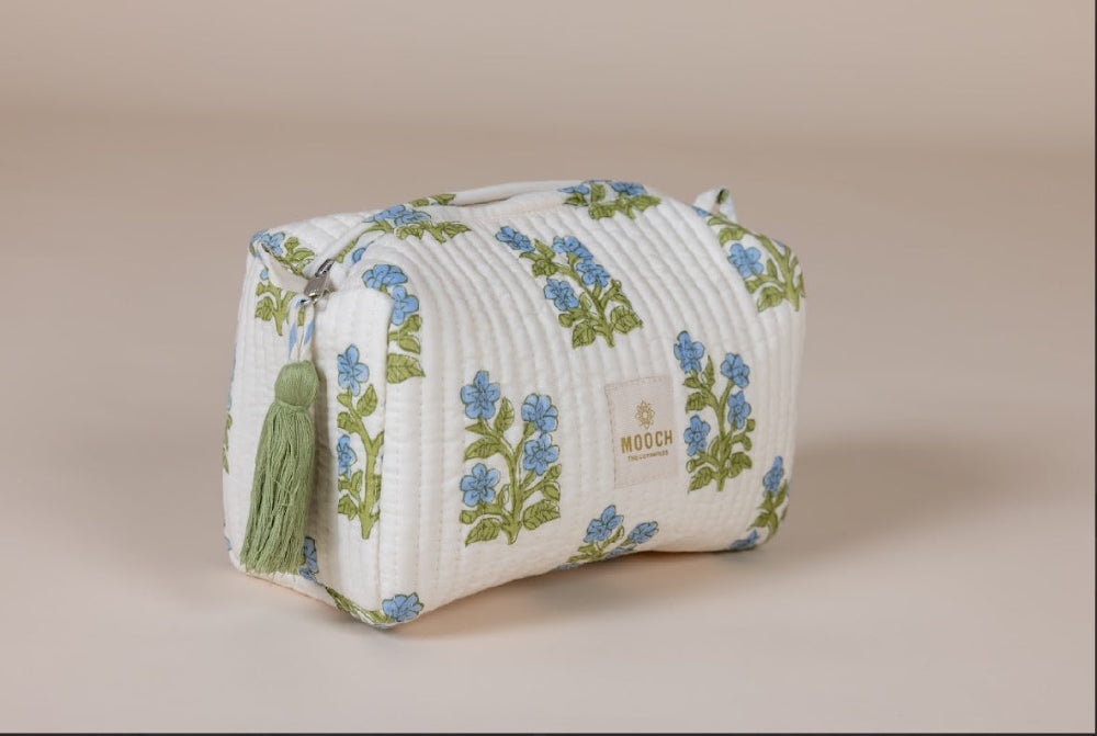 blue and green floral quilted cosmetic bag in a lifestyle image
