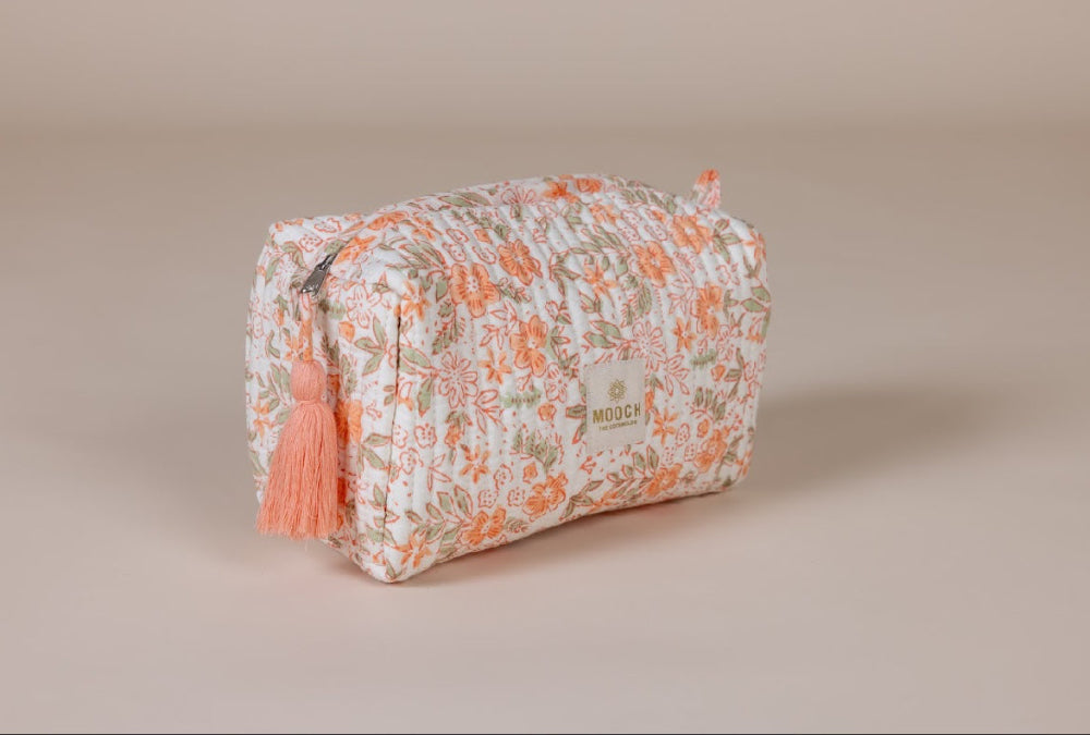 Floral patterned cosmetic bag with tassel on a beige background