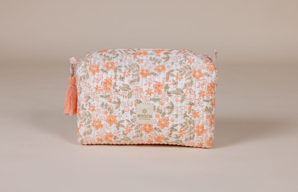 Floral patterned wash bag with tassel on a beige background